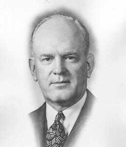 Black and white portrait of a distinguished man in formal suit, showcasing historical attire and prominence.