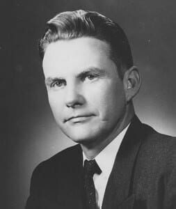 Old black and white portrait of a man in formal attire, historic photograph for museum exhibit.