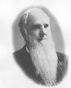 A historical photograph of an elderly man with a long beard and high collar.