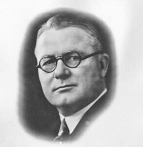Vintage black and white portrait of a man wearing glasses.