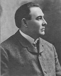 Young man in early 20th-century formal attire, vintage portrait for history museum exhibit.