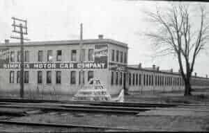 Historic brick building with American Stamp sign advertising Auto and Motor Car Company.