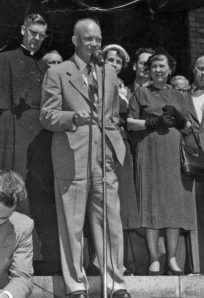Historic speech at The History Museum during a civil rights event. Black-and-white photo of diverse community leaders and activists outside a brick building.
