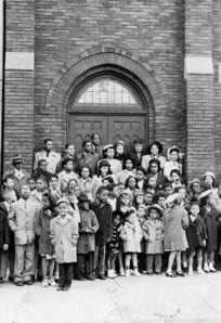 Historic African American school children group photo outside brick building.