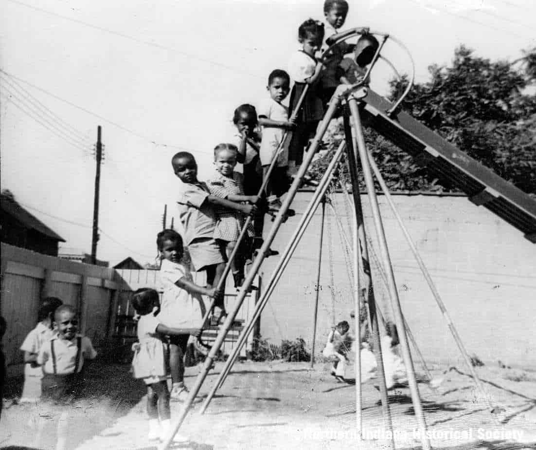 Hering House playground ph 7528 Children playing on a vintage playground slide, capturing historical moments of childhood recreation.