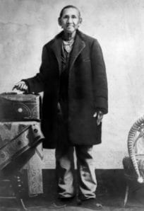 Old man with vintage suitcase and walking cane, historical photograph from the 19th century.