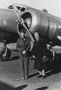 Vintage aircraft and two women standing in front, black and white photo from History Museum archives.