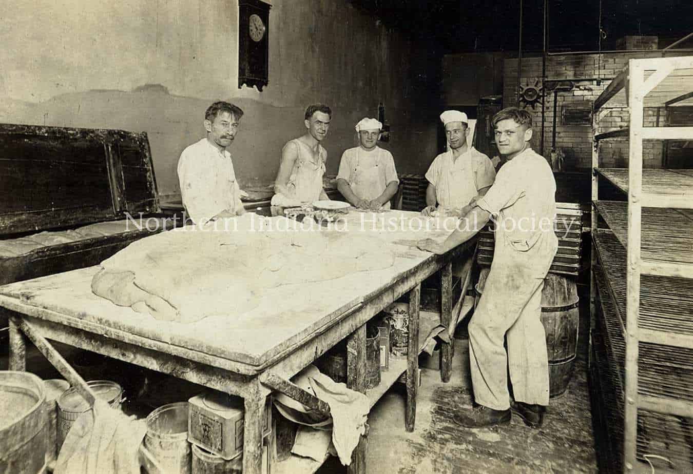 Rustic bakery kitchen with bakers preparing dough, vintage black and white photo at The History Museum.