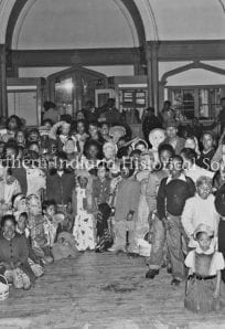 History museum interior with a large, diverse group of visitors and children.