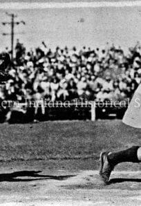Female baseball catcher reaching for ball during game, vintage black and white photo.