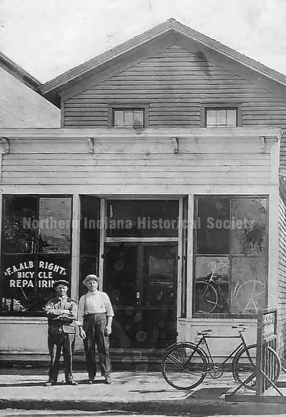 Old two-story historical building with bicycle repair shop, vintage bicycles outside, representing local history.