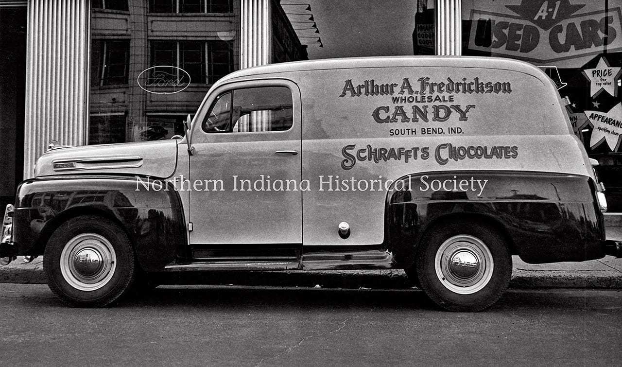 Vintage delivery truck advertising Arthur A. Fredrickson wholesale candy and Schrafft's chocolates in Indiana, black and white historic photo.