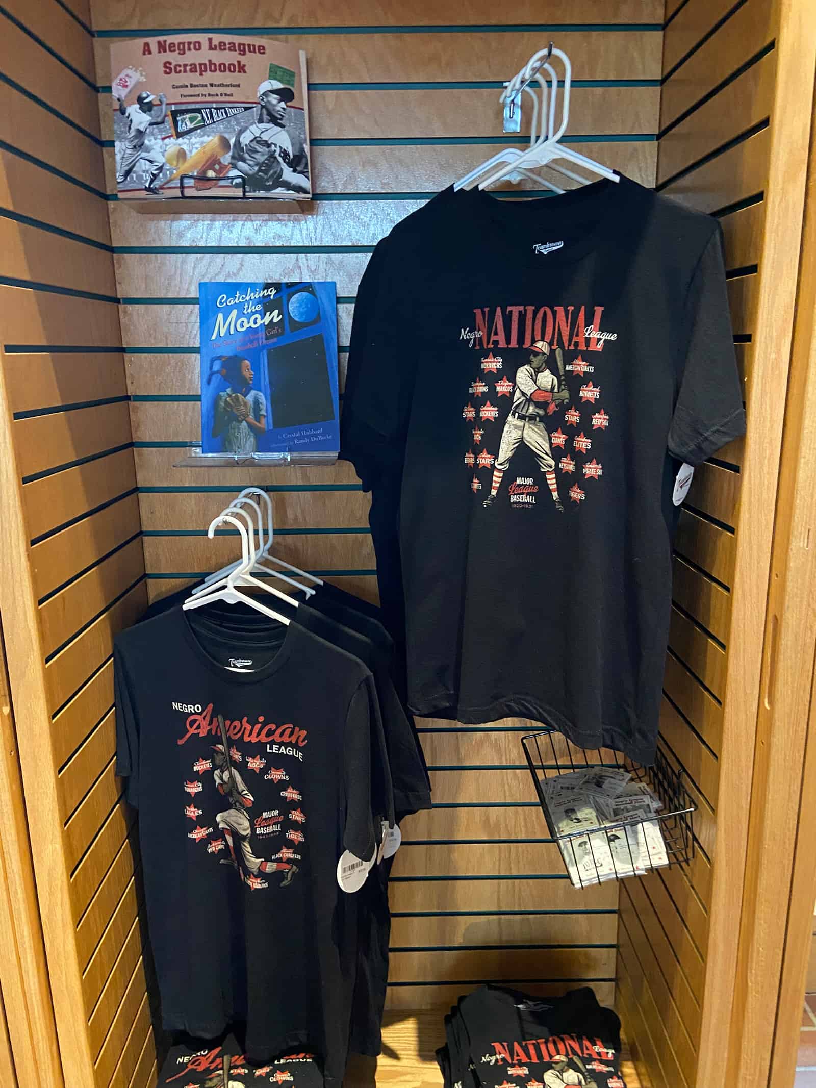 Negro League baseball T-shirts and memorabilia displayed in a museum exhibit.
