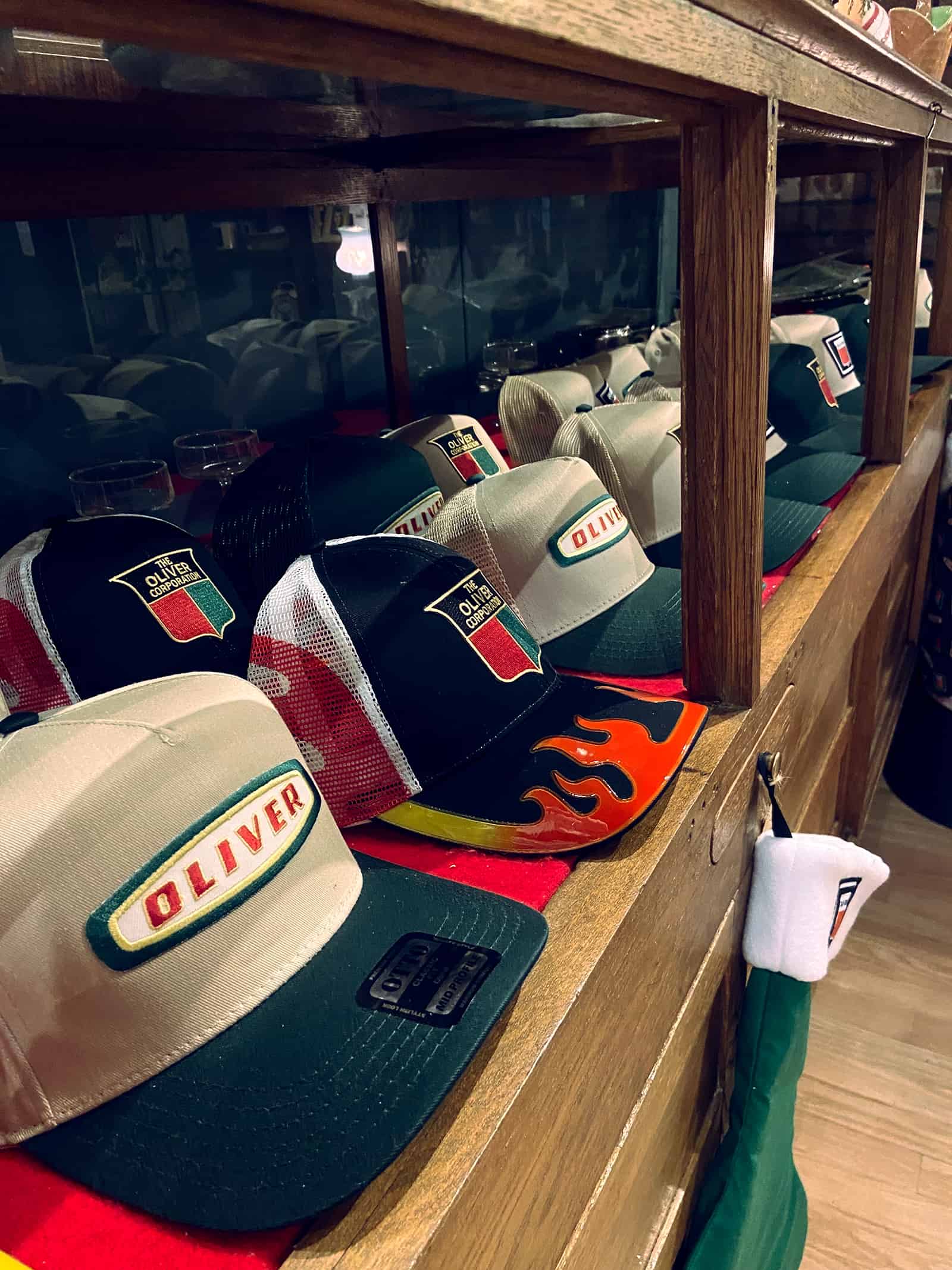 Vintage Oliver Racing caps displayed at The History Museum showcasing automotive history and memorabilia.