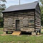 Weathered historic log cabin at The History Museum, showcasing early American pioneer architecture.