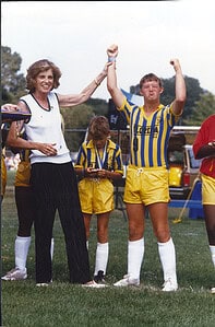 Victorious young woman celebrating with a sports team at The History Museum, showcasing historic sports moments and athletic history.