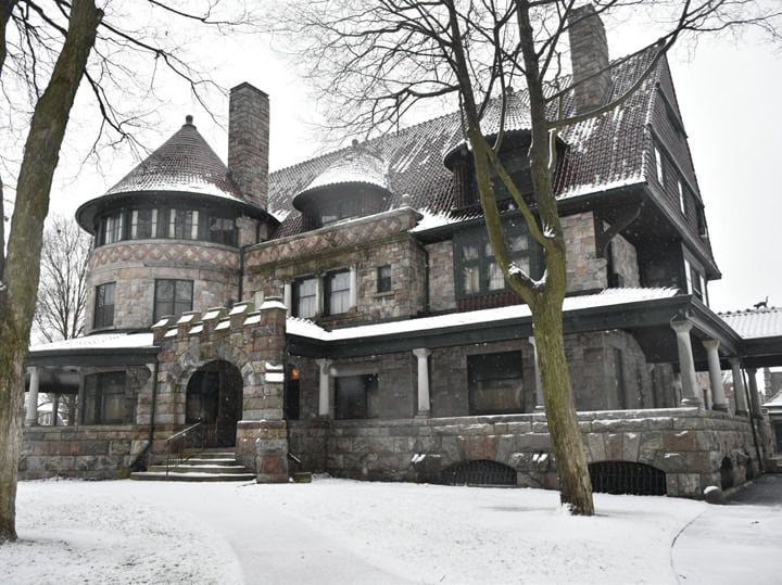 Victorian-style stone mansion covered in snow, showcasing historic architecture at The History Museum, a popular destination for exploring local history and preserving heritage.
